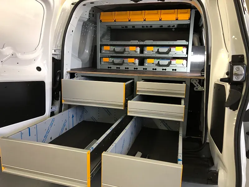 Fahrzeugeinrichtung mit Unterflurschubalden und Koffer im Türbereich